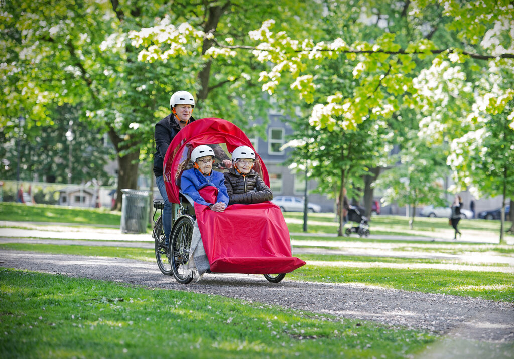 Eldre i sykkelvogn på sykkeltur med ansatt