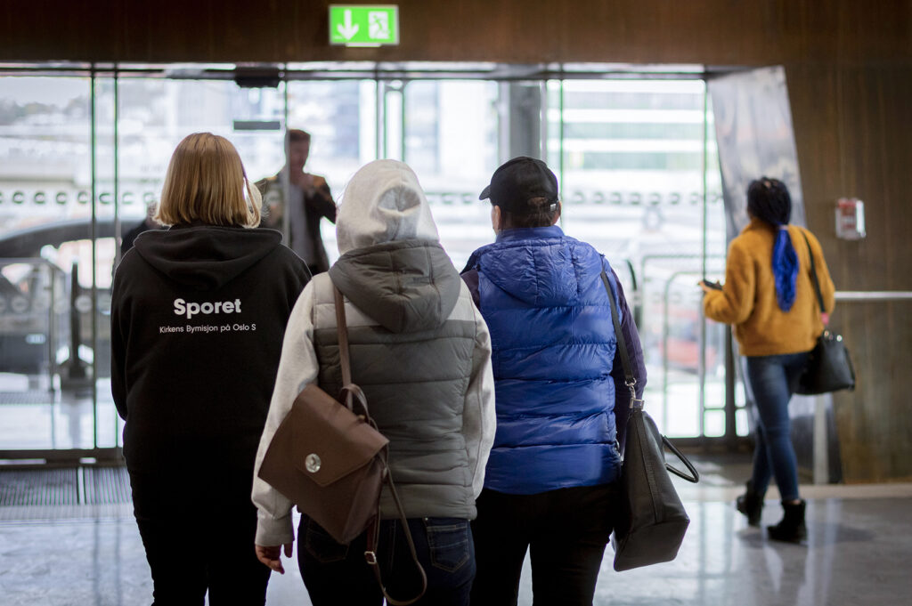 Frivillig som veileder to kvinner på Oslo S