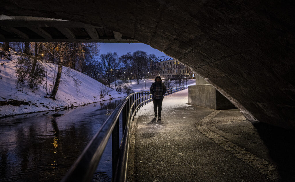 Person som går under en bro en mørk vinternatt