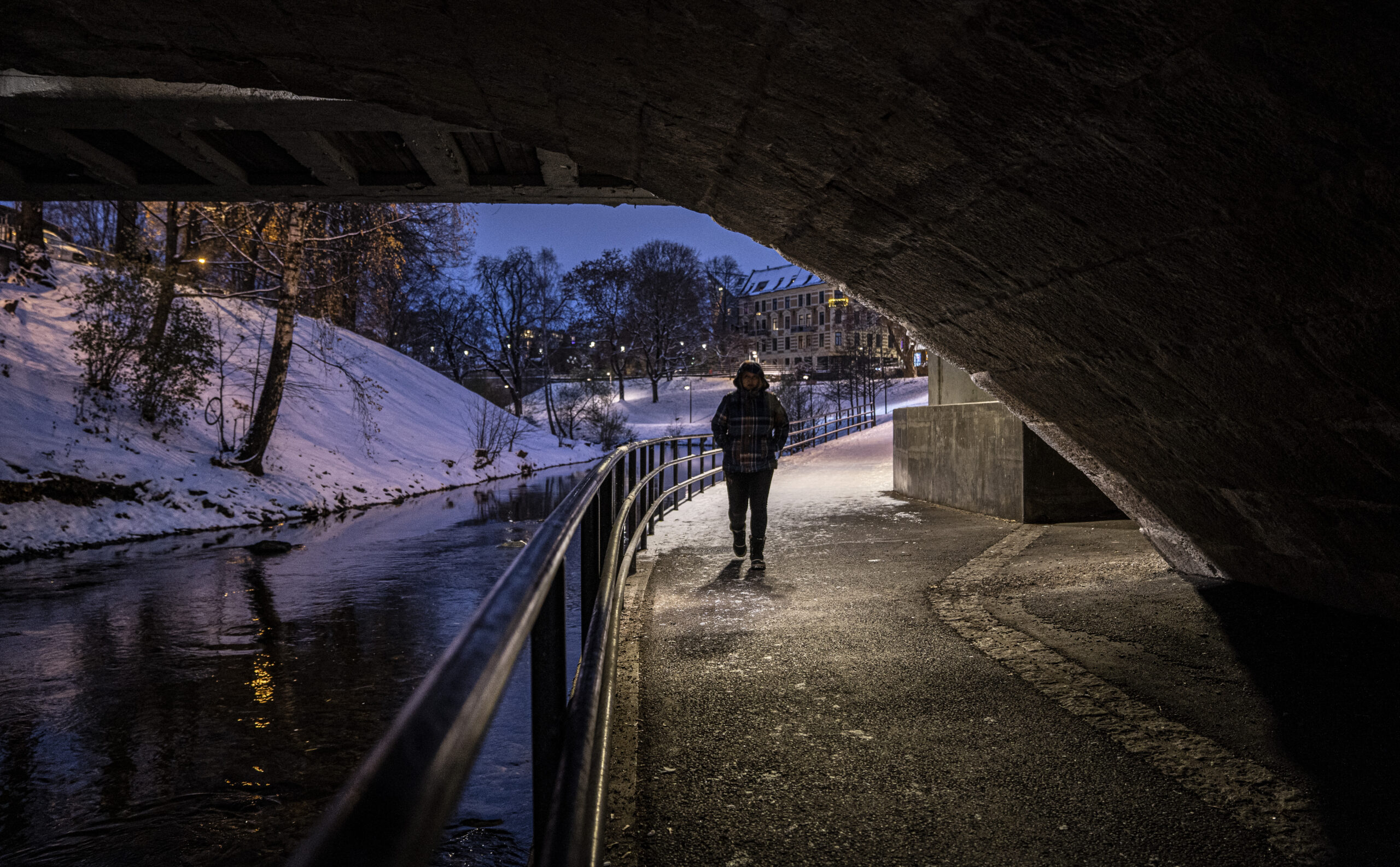 Person som går under en bro en mørk vinternatt