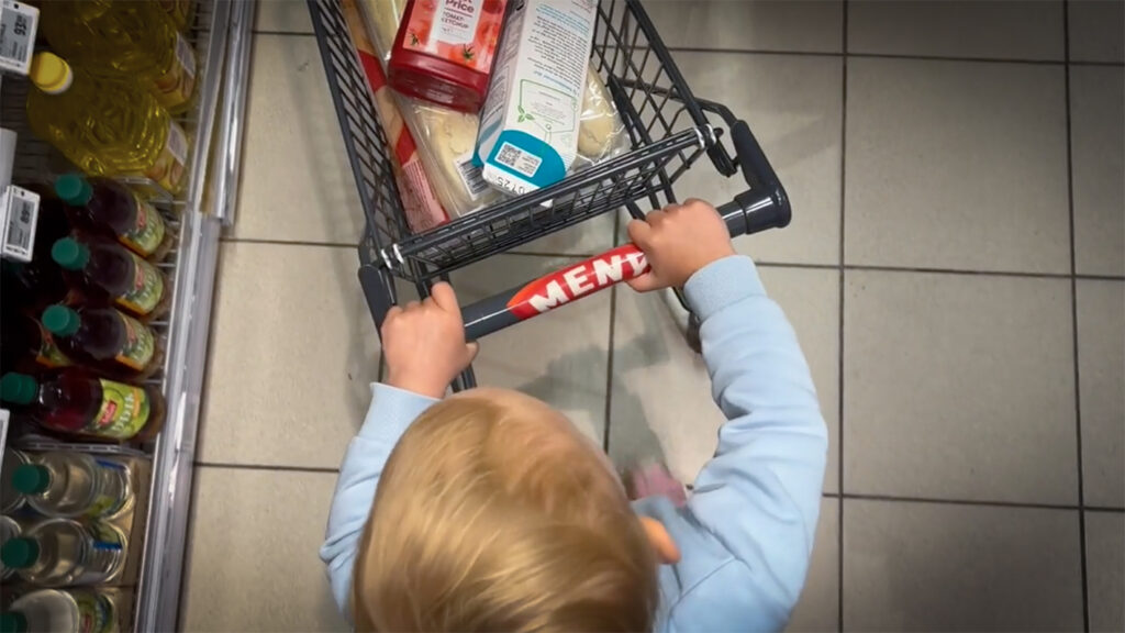 Barn med handlekurv i matbutikk