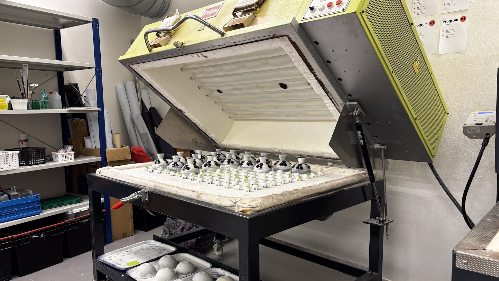 En stor ovn p&aring; verkstedet med mange glassk&aring;ler.