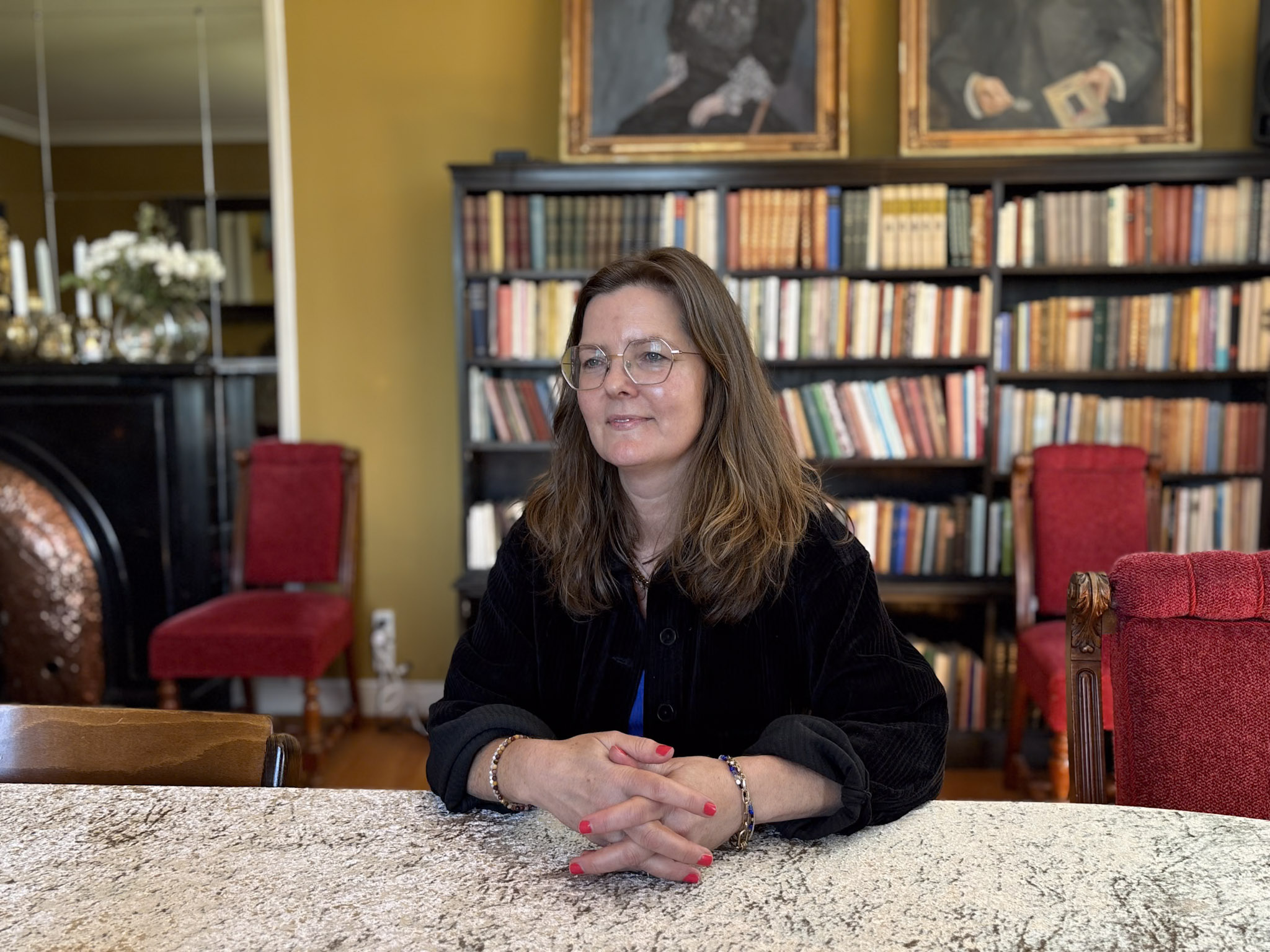 Avdelingsleder Elisabeth Haugseth sitter ved et bord med hendene foldet.