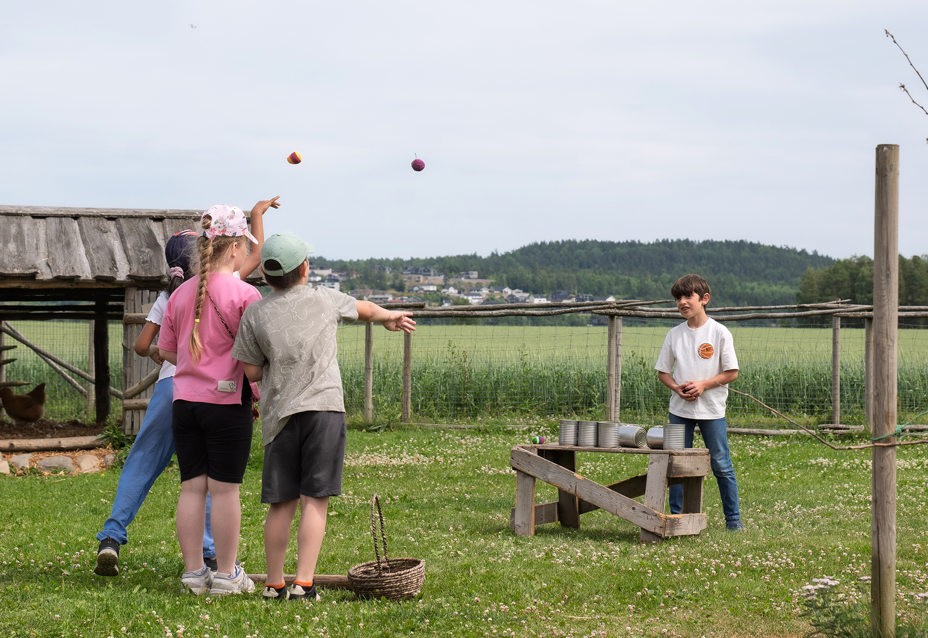 Fritidshuset i T&oslash;nsberg p&aring; sommercamp ved Ramnes S&oslash;ndre G&aring;rd. Barna kaster ball p&aring; blikkbokser