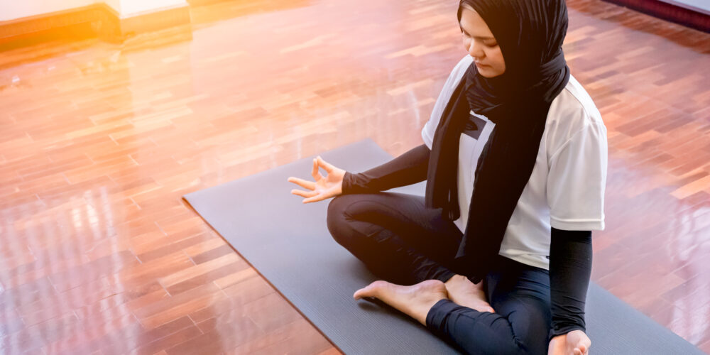 Kvinne med hijab som trenger yoga